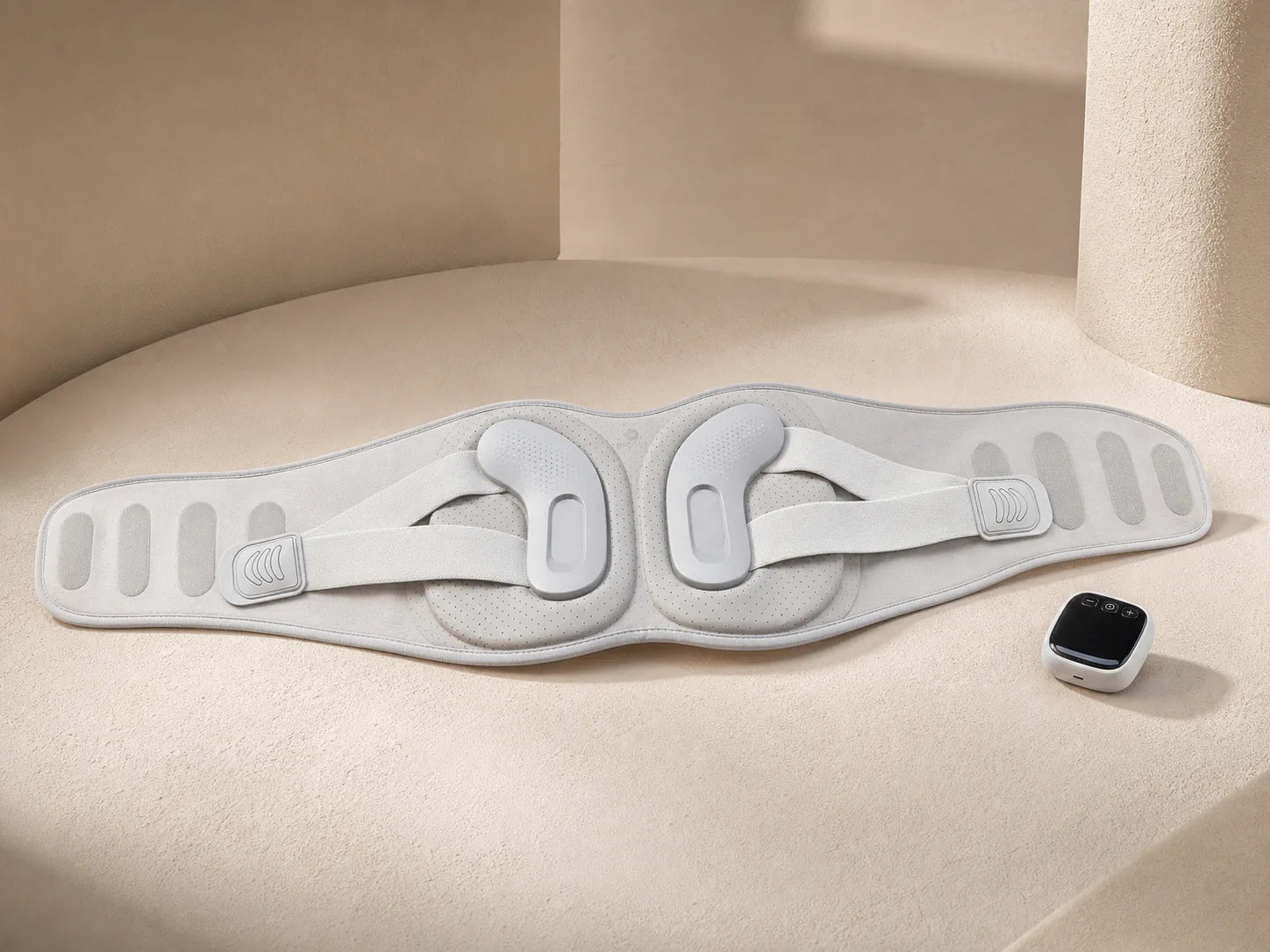 ESCOSY Lumbar One wrap and controller arranged on a warm studio surface